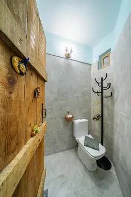 a bathroom with a toilet and a wooden wall at Artintime Apartments in Kotor