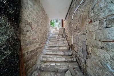 an alley with stone steps in a brick wall at Artintime Apartments in Kotor