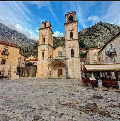 an old building with a clock tower in a courtyard at Artintime Apartments in Kotor