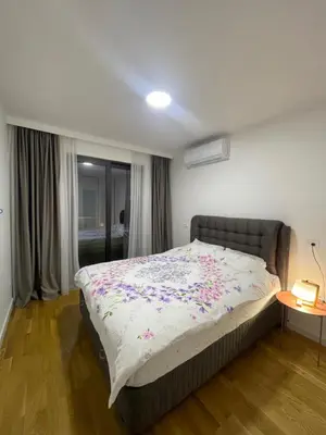 a bedroom with a large bed with flowers on it at Apartman Ognjen in Bar