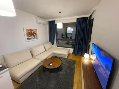 a living room with a white couch and a table at Apartman Ognjen in Bar