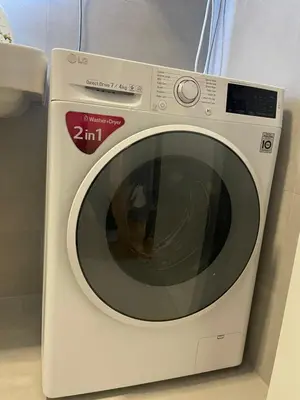 a white washing machine sitting in a bathroom at Apartman Ognjen in Bar