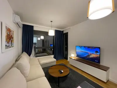 a living room with a white couch and a flat screen tv at Apartman Ognjen in Bar
