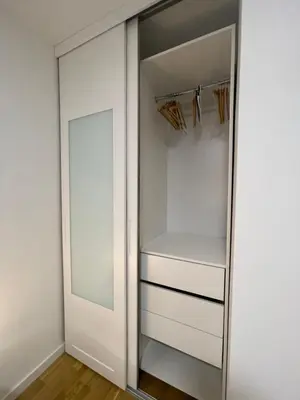 a walk in closet with white cabinets and a mirror at Apartman Ognjen in Bar