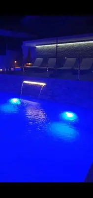 a swimming pool with blue lights in the dark at Meli Apartman in Krimovice
