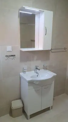 a white bathroom with a sink and a mirror at Meli Apartman in Krimovice