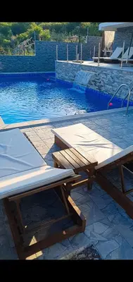 a wooden picnic table next to a swimming pool at Meli Apartman in Krimovice