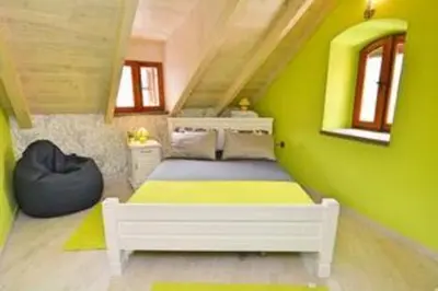 a bedroom with a bed with a green wall at Old Town Gem - Rooftop Terrace with Bay View in Kotor