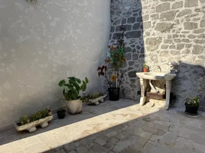 a group of potted plants sitting next to a wall at Old Town Gem - Rooftop Terrace with Bay View in Kotor