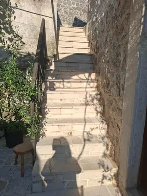 a shadow of a person walking down a staircase at Old Town Gem - Rooftop Terrace with Bay View in Kotor
