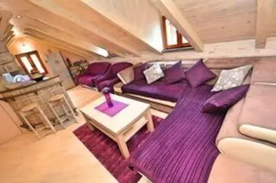 a living room with a purple couch and a table at Old Town Gem - Rooftop Terrace with Bay View in Kotor