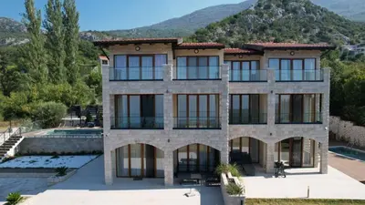 a large house with a mountain in the background at Villa Trend, Budva, Kuljače in Budva