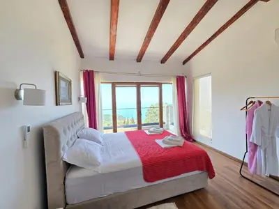 a bedroom with a bed with a red blanket and a window at Villa Trend, Budva, Kuljače in Budva