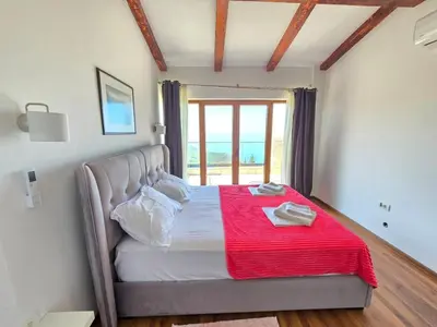 a bedroom with a bed with a red blanket on it at Villa Trend, Budva, Kuljače in Budva