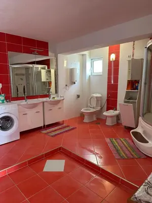 a bathroom with two toilets and a red tile floor at Marija 2 Apartman in Ulcinj