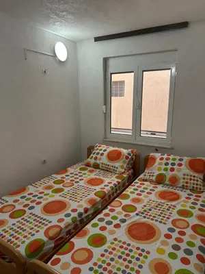 two beds sitting next to each other in a room at Marija 2 Apartman in Ulcinj