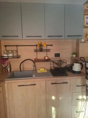 a kitchen with a sink and wooden cabinets at Romantic Escape - Stunning Rooftop Views - Old Town in Kotor