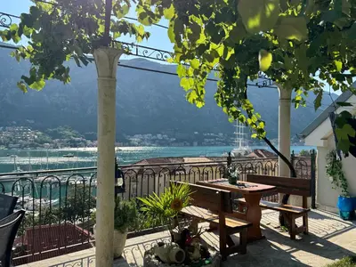 a balcony with a table and a view of the water at Romantic Escape - Stunning Rooftop Views - Old Town in Kotor