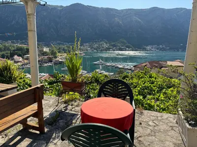 a table and chairs on a patio with a view of the water at Romantic Escape - Stunning Rooftop Views - Old Town in Kotor