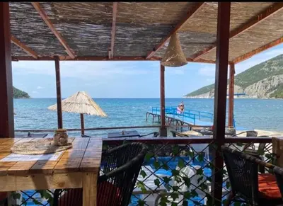 a view of the ocean from a resort with a table and chairs at Vila Dube in Ulcinj