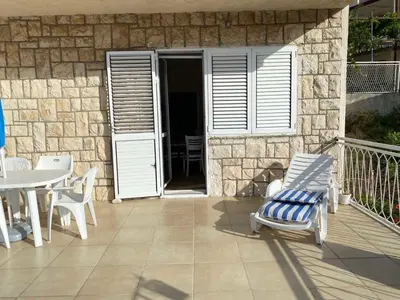 a patio with a chair and a table and a building at Vila Dube in Ulcinj