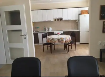 a kitchen with a table and chairs and a white refrigerator at Vila Dube in Ulcinj