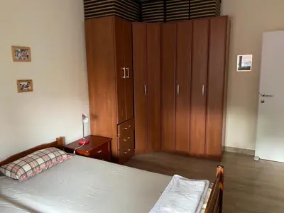 a bedroom with a bed and a large wooden cabinet at Vila Dube in Ulcinj