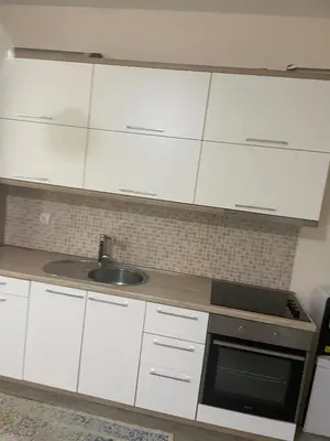 a kitchen with white cabinets and a sink at Leilighet i ulcinj in Ulcinj