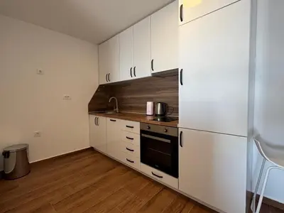a kitchen with white cabinets and a refrigerator at Apartment Alex in Dobra Voda