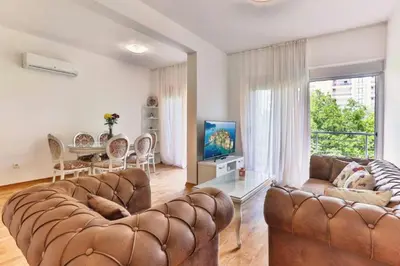 a living room with two leather couches and a table at Lux Apartment KORDA in Rafailovici
