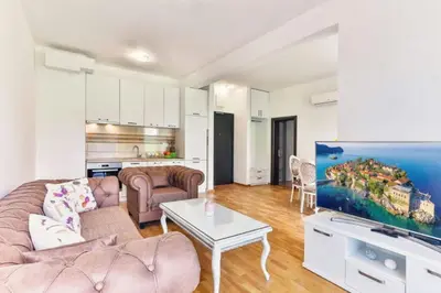 a living room with a couch and a tv at Lux Apartment KORDA in Rafailovici