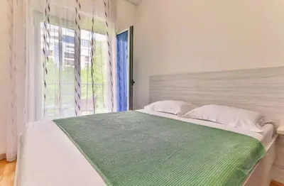a bedroom with a large bed with a window at Lux Apartment KORDA in Rafailovici