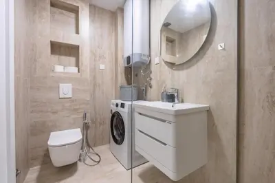 a bathroom with a washing machine and a sink at Wave Apartments - Dobra Voda in Bar