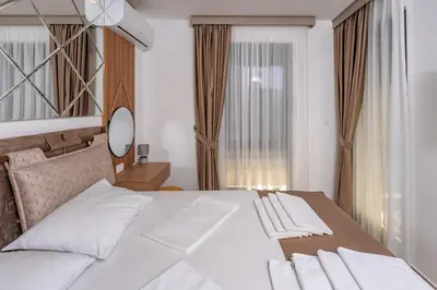 a bedroom with a large white bed and a window at Wave Apartments - Dobra Voda in Bar