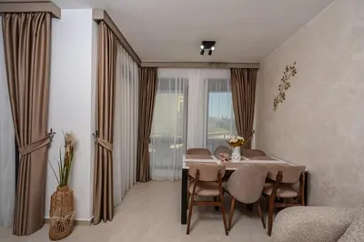 a living room with a dining room table with chairs at Wave Apartments - Dobra Voda in Bar