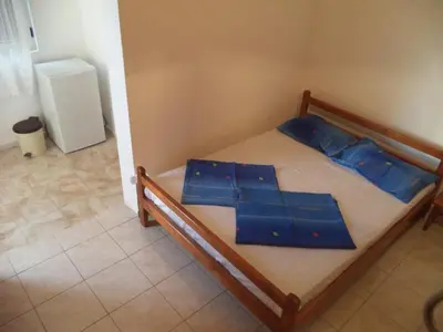 a bedroom with a bed with blue pillows on it at Vito Apartments Sutomore in Sutomore