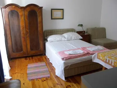 a bedroom with a large bed with a wooden headboard at Apartments Markovic Sutomore in Sutomore