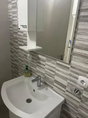 a bathroom with a white sink and a mirror at Apartment D&A in Ulcinj