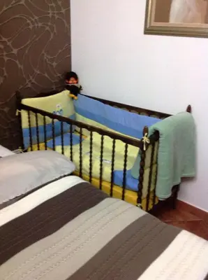 a baby in a crib in a bedroom at BMB Apartments Kotor in Kotor