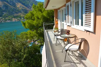 a balcony of a house with chairs and a table at BMB Apartments Kotor in Kotor