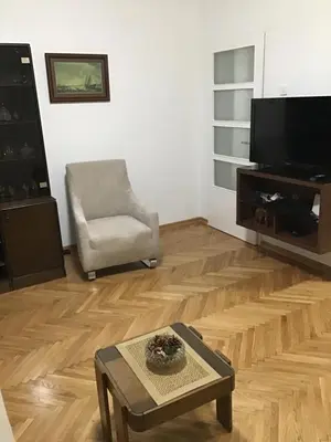 a living room with a tv and a chair and a table at BMB Apartments Kotor in Kotor