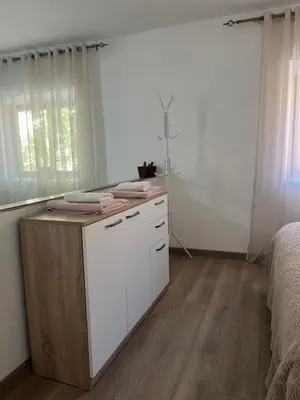 a bedroom with a bed and a dresser with towels on it at Apartment Stari Konak in Virpazar