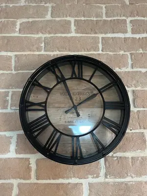 a black clock hanging on a brick wall at Apartment Stari Konak in Virpazar