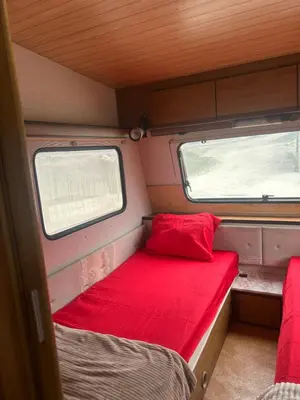 a small room with a red bed and two windows at A little paradise in Kotor