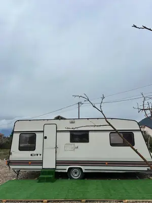a white rv parked in a field at A little paradise in Kotor