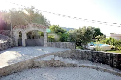 a house with a stone gate and a driveway at Villa Rezevici in Katun