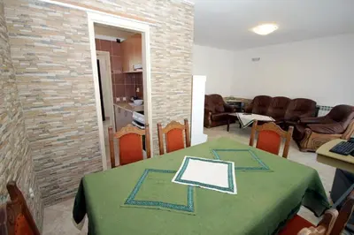 a dining room with a table with a green table cloth at Villa Rezevici in Katun