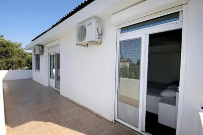a white building with a balcony with a bed at Villa Rezevici in Katun