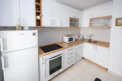 a kitchen with white cabinets and a white refrigerator at Apartment Marko in Kotor