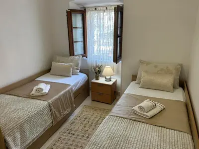 a bedroom with two beds and a window at Apartment Marko in Kotor
